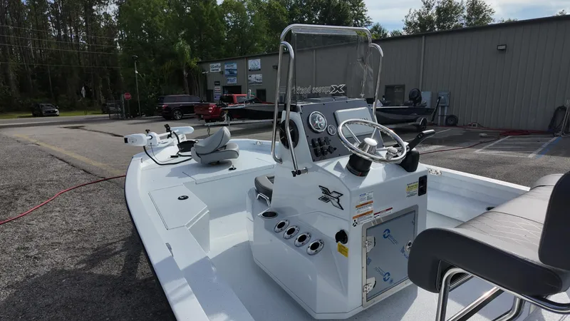 Slide: The Image of 2026 Xpress H20 boat with steering console, parked outdoors near a building. - 16
