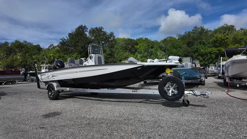 Slide: The Image of 2026 Xpress H20 boat on trailer, parked outdoors under a blue sky. - 2