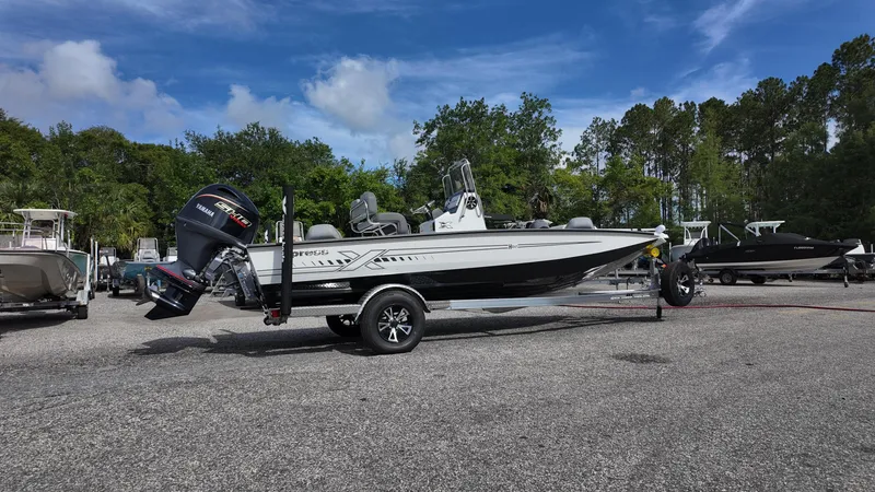 Slide: The Image of 2026 Xpress H20 boat on trailer in outdoor lot, surrounded by trees and other boats. - 4