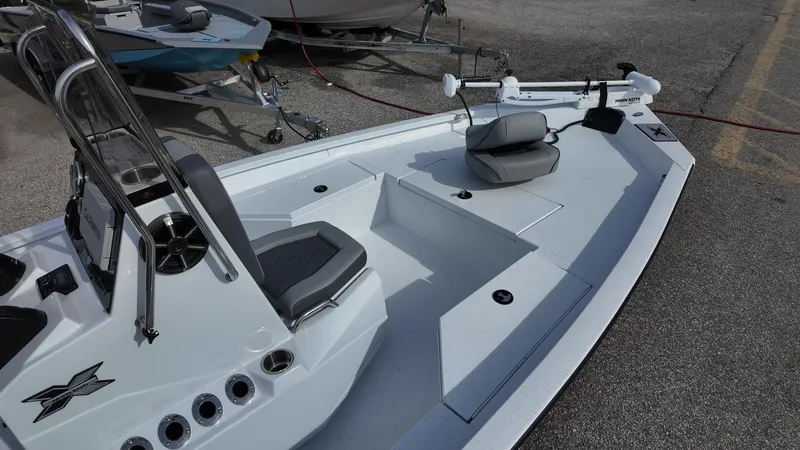 Slide: The Image of 2026 Xpress H20 boat with seating and steering console, parked on pavement. - 9