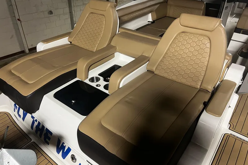 Slide: The Image of 2019 Sea Ray SDX 290 boat interior with tan leather seating and cup holders. - 13