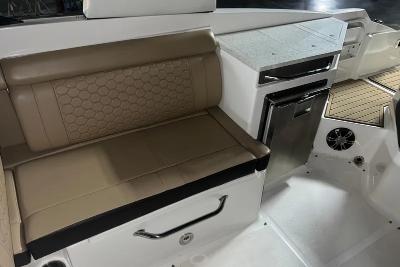 Slide: The Image of 2019 Sea Ray SDX 290 interior with beige seating and compact kitchenette. - 15