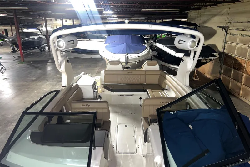Slide: The Image of 2019 Sea Ray SDX 290 boat interior in a storage facility, showcasing seating and speakers. - 20