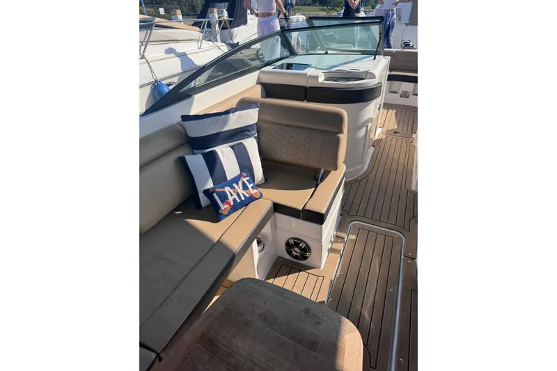 Slide: The Image of 2019 Sea Ray SDX 290 boat interior with cushioned seating and nautical-themed pillows. - 5