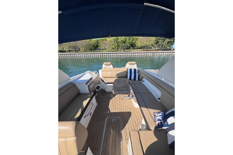 Slide: The Image of 2019 Sea Ray SDX 290 boat interior with cushioned seating and wooden flooring. - 6