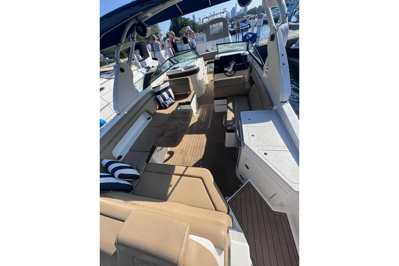 Slide: The Image of 2019 Sea Ray SDX 290 boat interior with tan seating and striped cushions. - 7