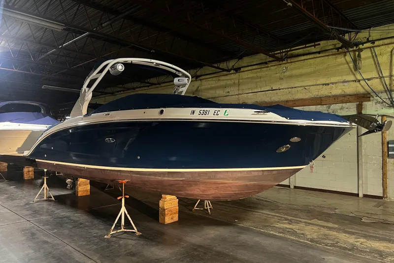 Slide: The Image of 2019 Sea Ray SDX 290 boat in storage, blue hull, indoor warehouse setting. - 9