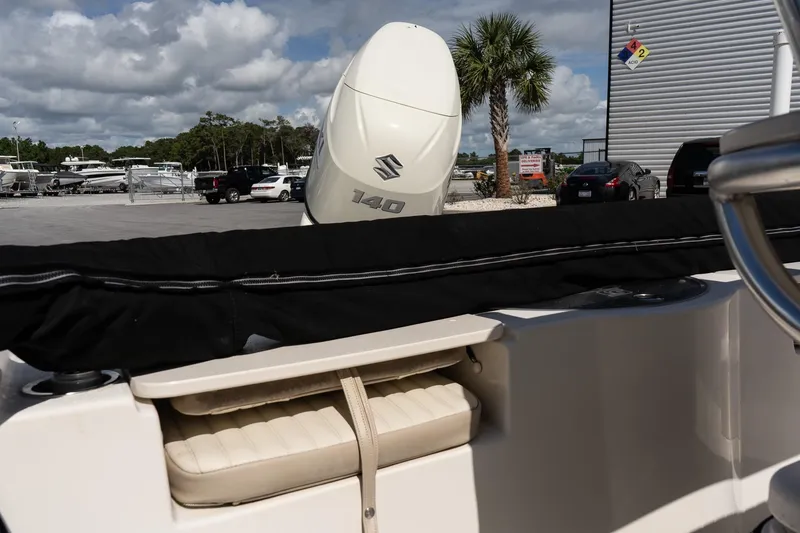 Slide: The Image of 2017 Carolina Skiff 218 DLV boat with Suzuki 140 engine in a marina setting. - 14