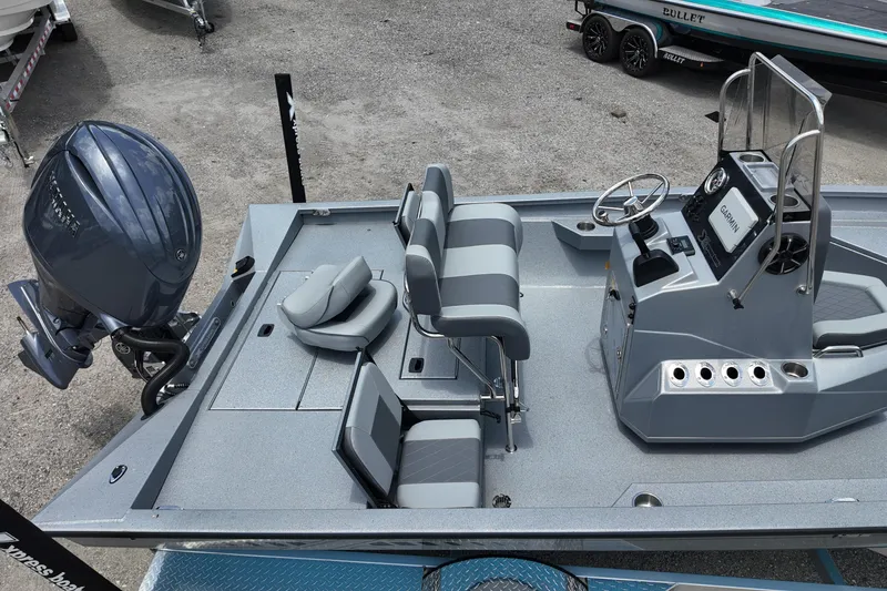 Slide: The Image of 2026 Xpress H22B Bay boat interior with seating, steering console, and outboard motor. - 7