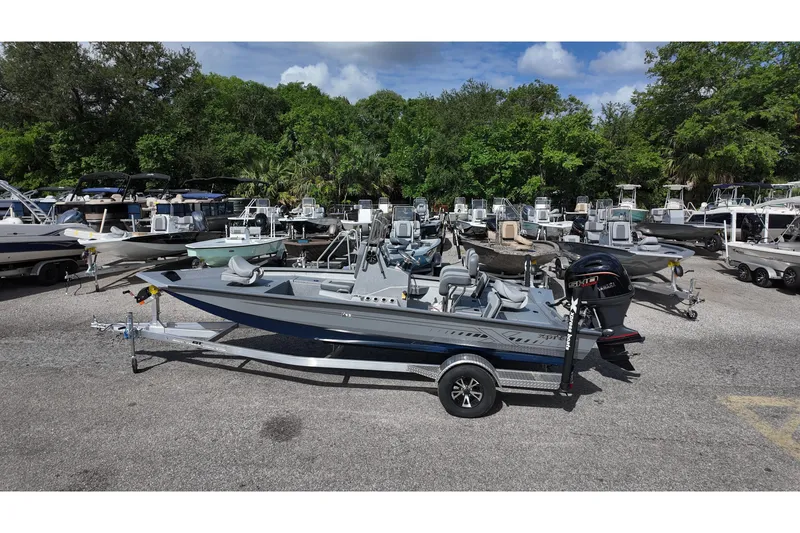 Slide: The Image of 2026 Xpress H20B Bay boat on trailer in a marina with other boats. - 1