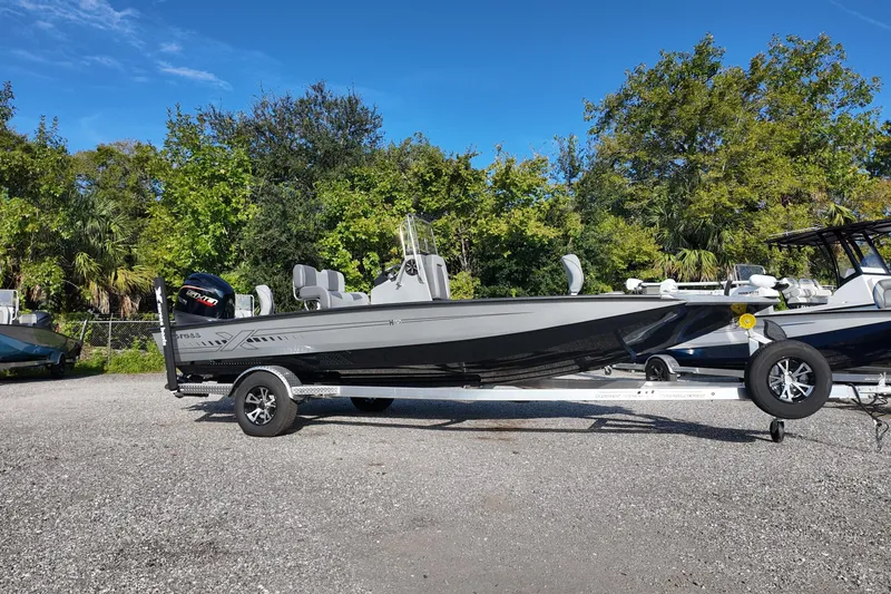 Slide: The Image of 2026 Express H20B boat on trailer, parked outdoors with trees in background. - 3