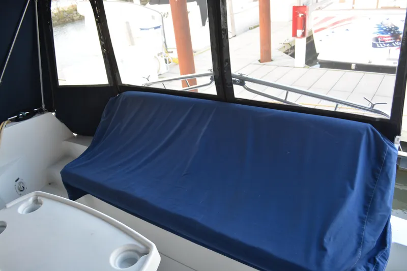Slide: The Image of 1995 Carver 380 Santego boat interior with blue-covered seating area. - 11