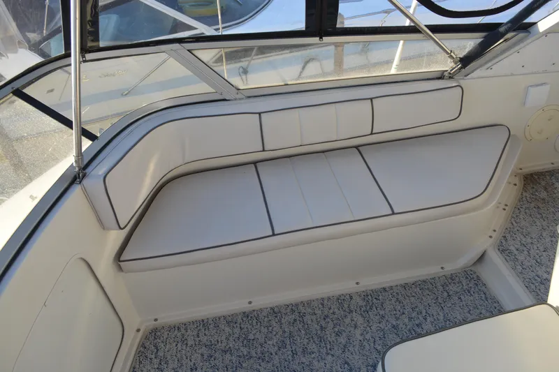 Slide: The Image of 1995 Carver 380 Santego boat interior with white cushioned seating and carpeted floor. - 17