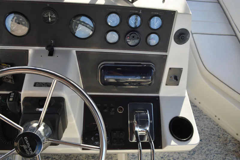 Slide: The Image of Control panel of a 1995 Carver 380 Santego boat with steering wheel and gauges. - 21
