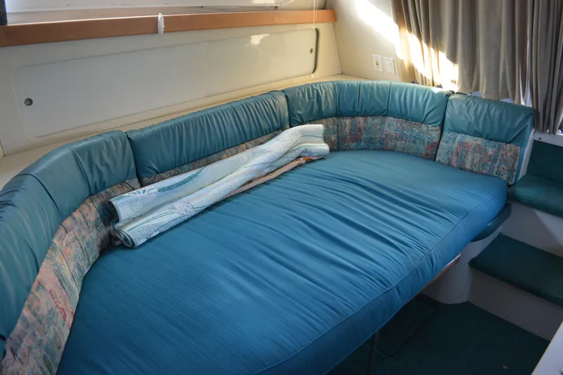 Slide: The Image of Interior of 1995 Carver 380 Santego yacht with blue cushioned seating area. - 26