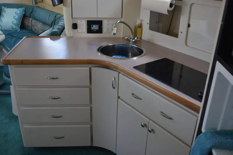 Slide: The Image of 1995 Carver 380 Santego yacht kitchen with sink, stove, and storage cabinets. - 37