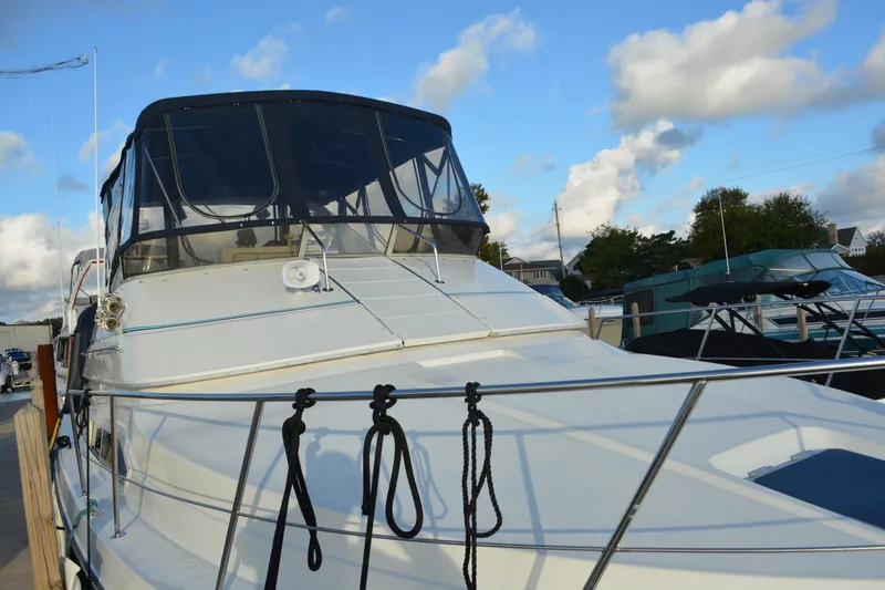 Slide: The Image of 1995 Carver 380 Santego yacht docked under a blue sky with clouds. - 4