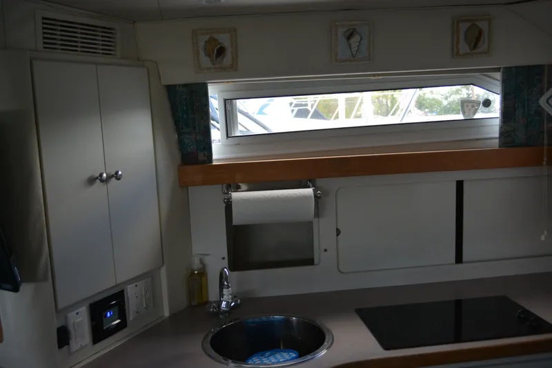 Slide: The Image of Interior of 1995 Carver 380 Santego yacht kitchen with sink, stove, and window. - 40