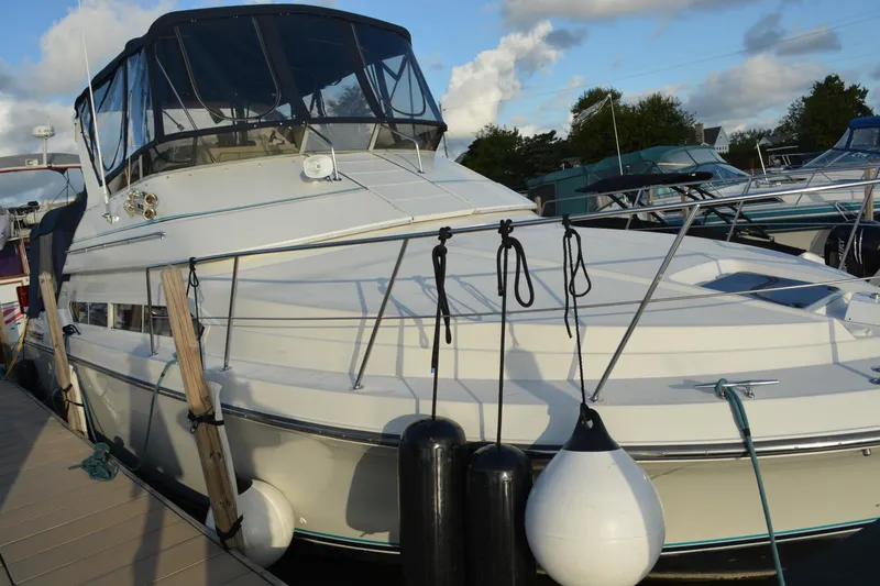 Slide: The Image of 1995 Carver 380 Santego yacht docked with fenders, under a partly cloudy sky. - 5