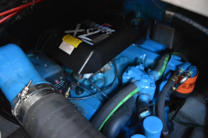 Slide: The Image of Engine compartment of a 1995 Carver 380 Santego boat, featuring blue components and hoses. - 54