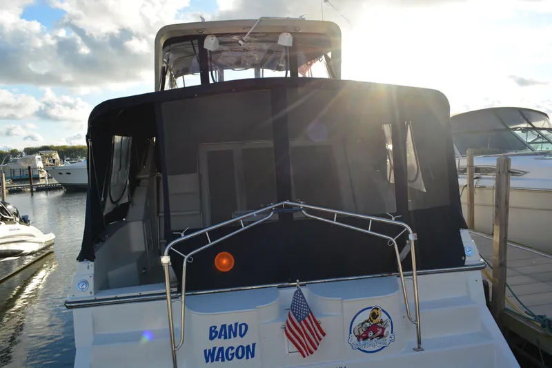 Slide: The Image of 1995 Carver 380 Santego boat docked, rear view with American flag and sun flare. - 9