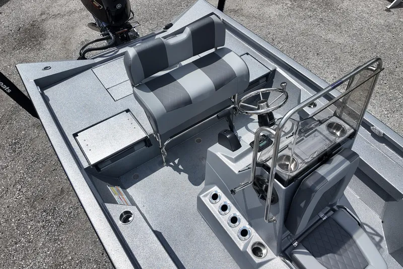 Slide: The Image of 2026 Express H20B Bay boat interior with steering console, seating, and storage compartments. - 6