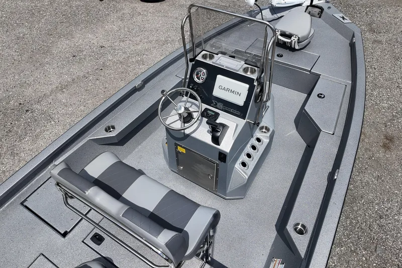 Slide: The Image of 2026 Express H20B Bay boat interior with steering console and seating, featuring Garmin electronics. - 7