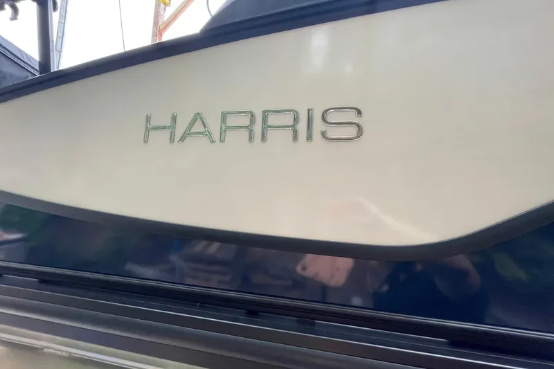Slide: The Image of 2026 Harris Sunliner 210 boat with sleek design and prominent logo. - 2