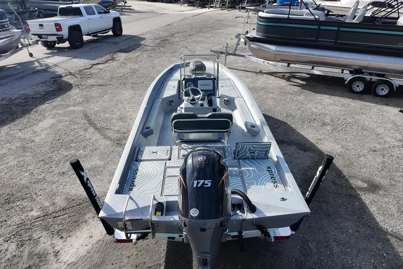 Slide: The Image of 2026 Xpress H22B Bay boat with 175 HP engine, parked in a marina. - 5