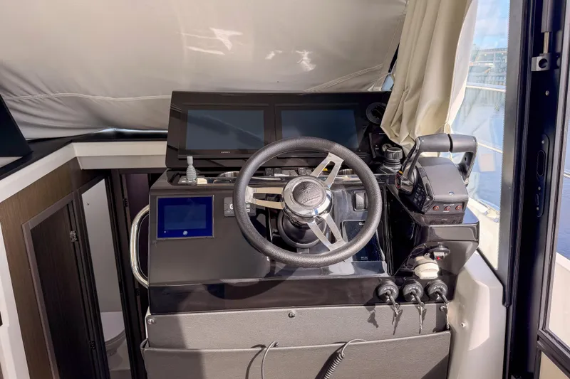 Slide: The Image of 2025 Jeanneau NC 1295 Fly yacht on clear blue water, city skyline in background. - 4