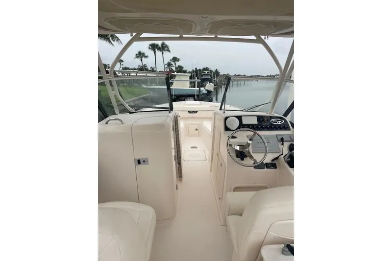 Slide: The Image of 2015 Grady-White Freedom 285 boat docked by the water, showcasing spacious seating and helm. - 9