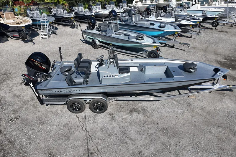 Slide: The Image of 2026 Xpress H24B Bay boat on trailer in a dealership lot. - 1