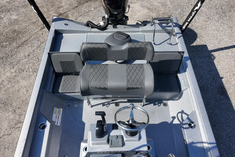 Slide: The Image of 2026 Xpress H24B Bay boat interior with gray seating and steering wheel. - 19