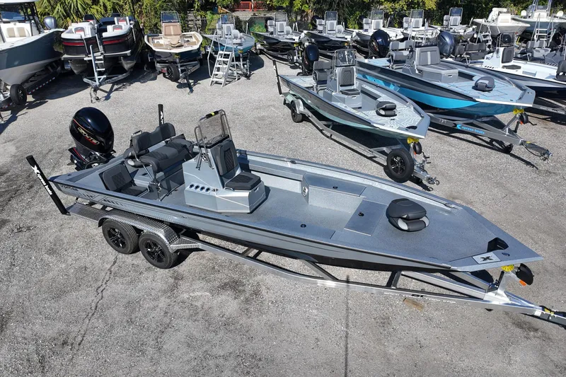 Slide: The Image of 2026 Xpress H24B Bay boat on trailer, surrounded by other boats in a dealership lot. - 5