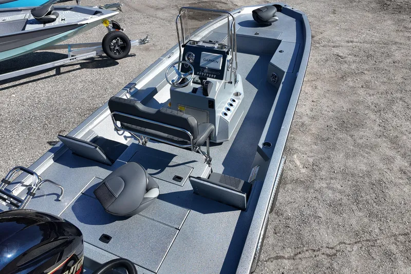 Slide: The Image of 2026 Xpress H24B Bay boat with modern console and seating, parked on gravel. - 8