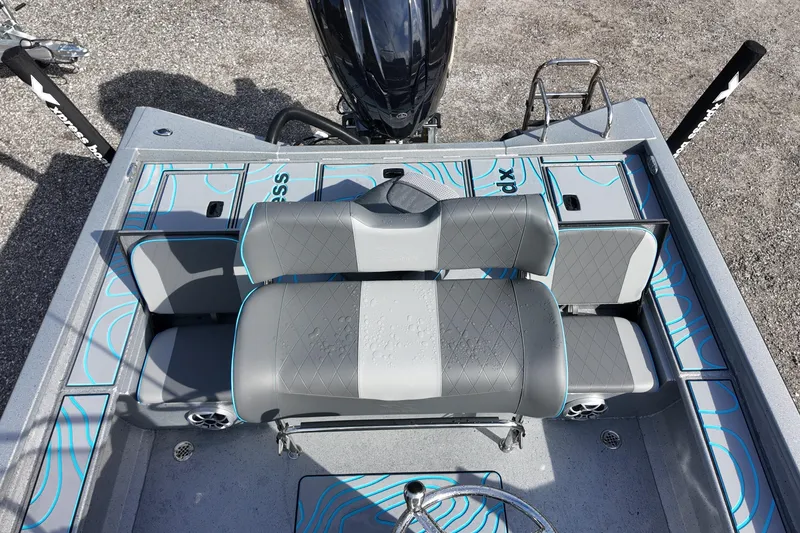 Slide: The Image of 2026 Xpress X23B Bay Lounge boat interior with gray seating and blue accents. - 17