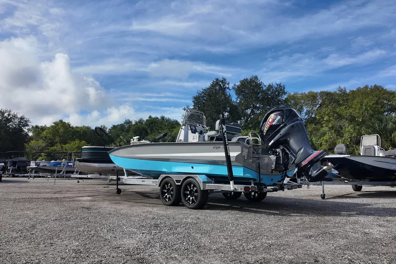 Slide: The Image of 2026 Xpress X23B Bay Lounge boat on trailer, parked outdoors under blue sky. - 4