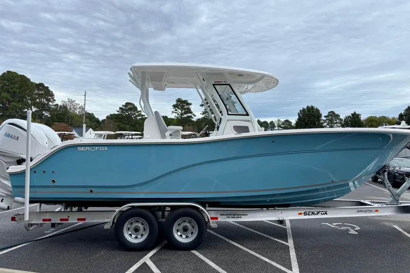 Slide: The Image of 2026 Sea Fox 288 Commander boat on trailer, blue hull, parked outdoors. - 1