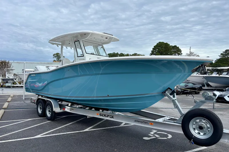 Slide: The Image of 2026 Sea Fox 288 Commander boat on trailer, blue hull, parked outdoors. - 3
