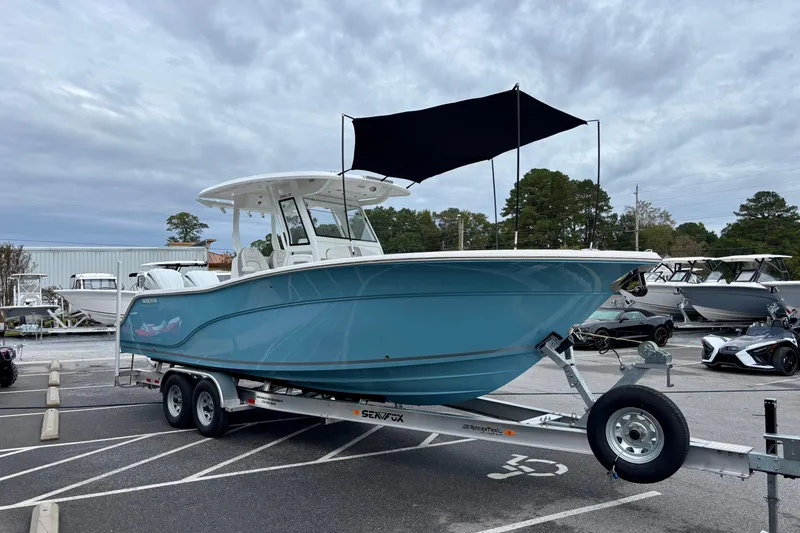 Slide: The Image of 2026 Sea Fox 288 Commander boat on trailer, blue hull, parked outdoors. - 5