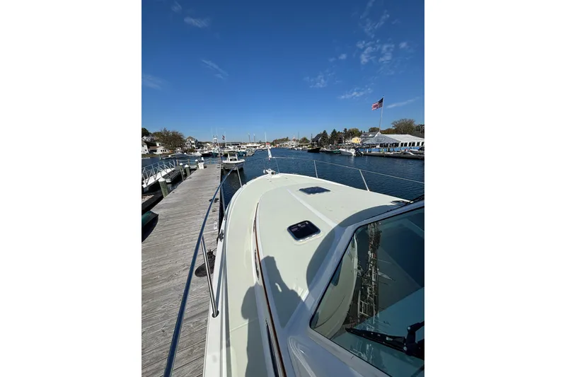 Slide: The Image of 2020 Back Cove 37 yacht docked at a marina under a clear blue sky. - 10