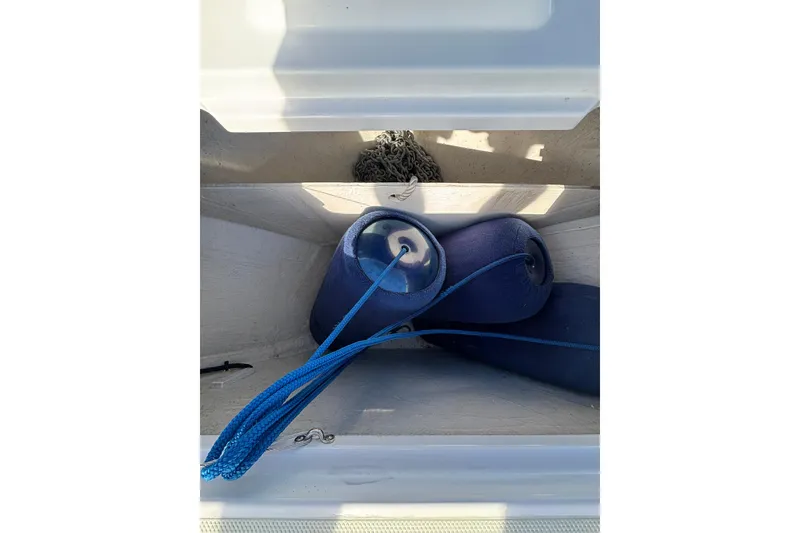 Slide: The Image of Storage compartment on a 2020 Back Cove 37 boat with blue fenders and rope. - 12