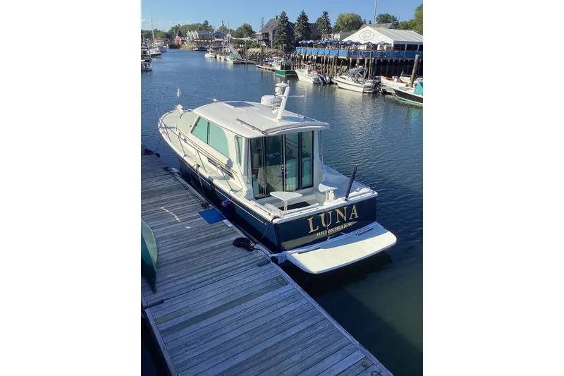 Slide: The Image of 2020 Back Cove 37 boat "Luna" docked in a scenic marina. - 2