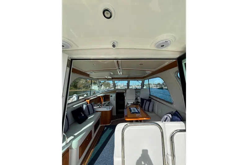 Slide: The Image of Interior view of 2020 Back Cove 37 yacht, featuring elegant seating and a scenic water backdrop. - 23