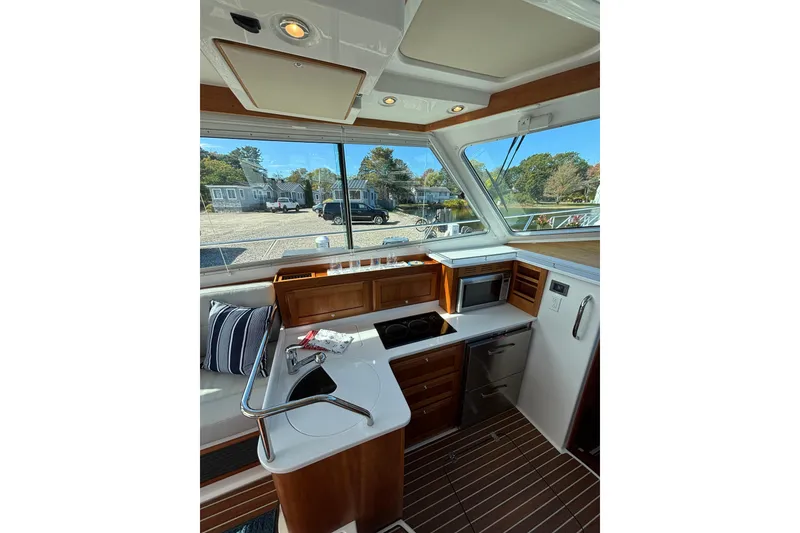 Slide: The Image of Interior of 2020 Back Cove 37 yacht, featuring a modern kitchen with wood accents. - 27