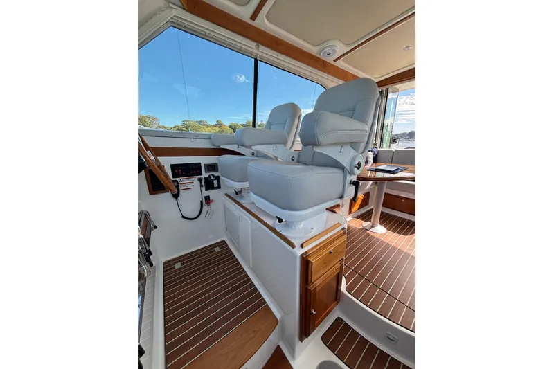 Slide: The Image of 2020 Back Cove 37 interior with helm seats and wooden flooring. - 28