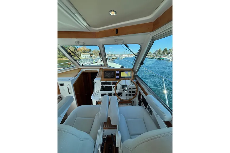 Slide: The Image of Interior view of 2020 Back Cove 37 yacht helm with navigation equipment and waterfront scenery. - 29