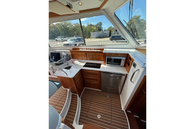 Slide: The Image of 2020 Back Cove 37 yacht interior with modern kitchen, wood flooring, and large windows. - 30