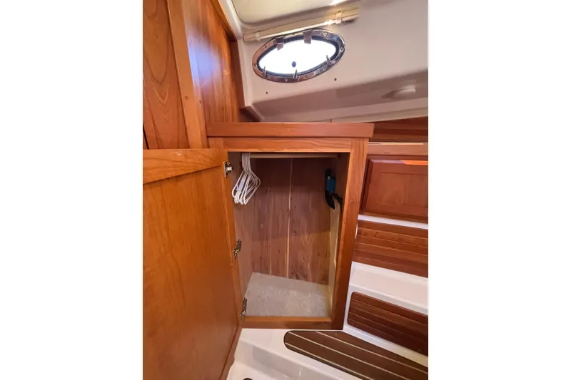 Slide: The Image of 2020 Back Cove 37 interior wooden closet with hangers and porthole. - 39