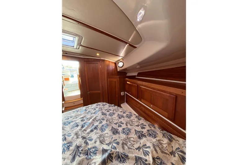 Slide: The Image of 2020 Back Cove 37 cabin interior with wood paneling and floral bedding. - 43